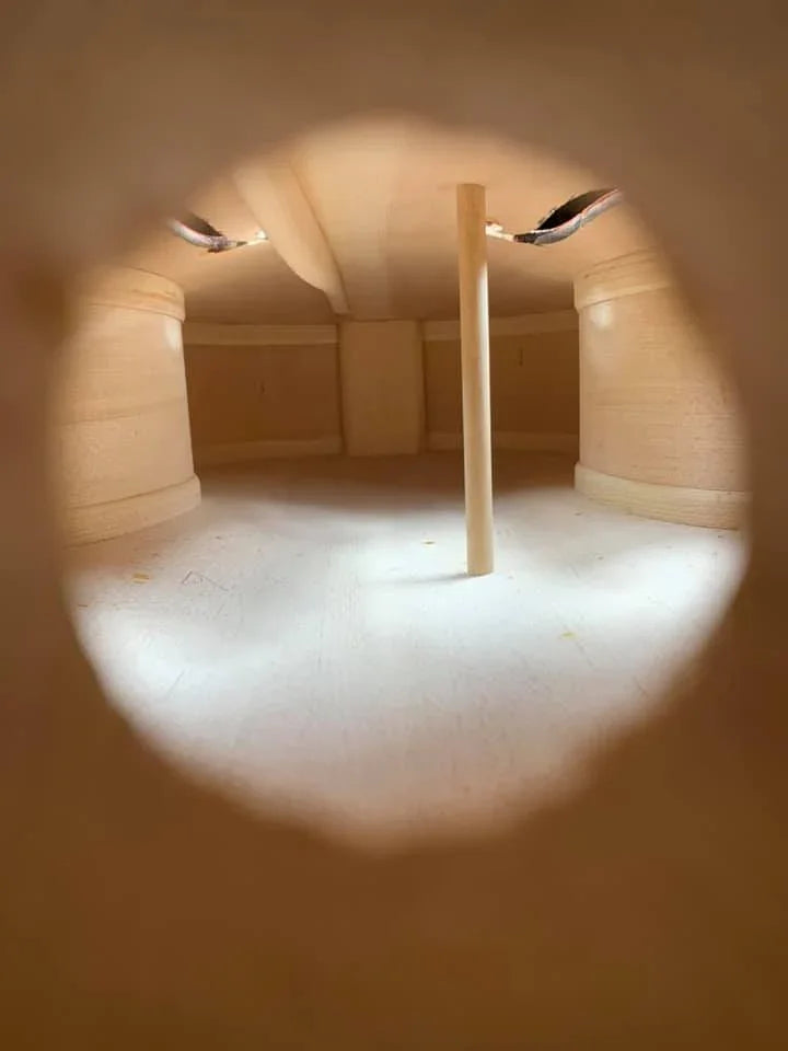 Interior view of violin during StringWorks expert inspection process showing soundpost and construction quality assessment